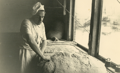 827325 Afbeelding van een medewerker van bakkerij J.W.A. Mulder (Dorpstraat C8) te Harmelen, tijdens het kneden van het deeg.